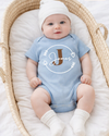 Baby wearing a blue onesie with name