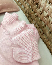 Pink textured fabric on a surface with a woven beige background