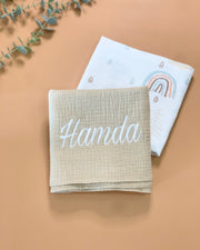 Muslin Swaddle plain and rainbow print on a flatlay